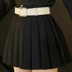 close‑up of white belt and black pleated skirt